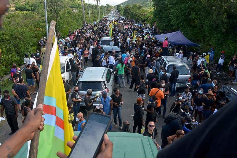 Bewoners van St. Maarten en St. Martin gingen de straat op tegen het besluit om de grenzen op het eiland te sluiten tijdens de Covid pandemie. Enkelen zwaaien de "Unity Flag" tijdens deze "Únity March".
